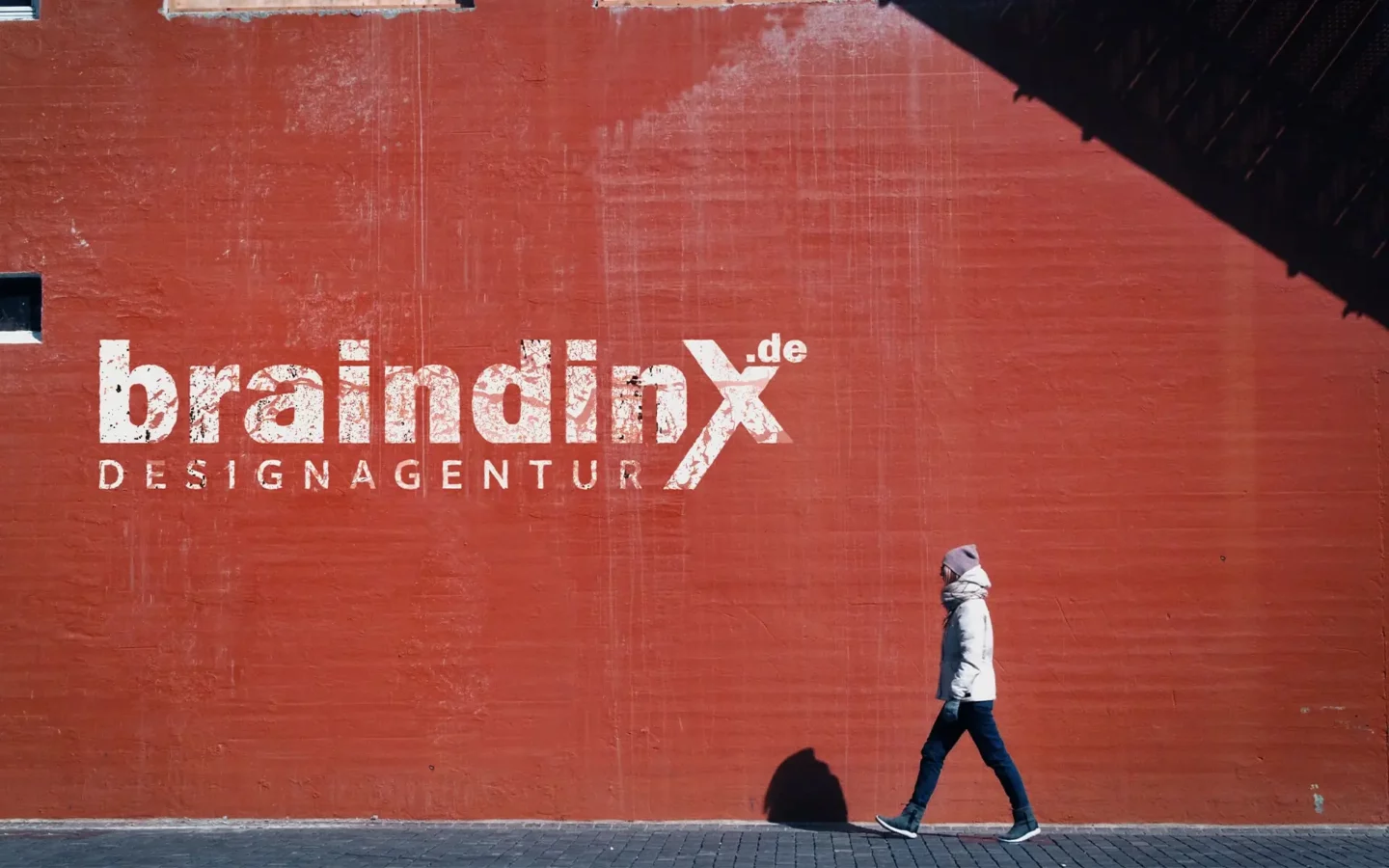 braindinx Designagentur Logo auf roter Hauswand