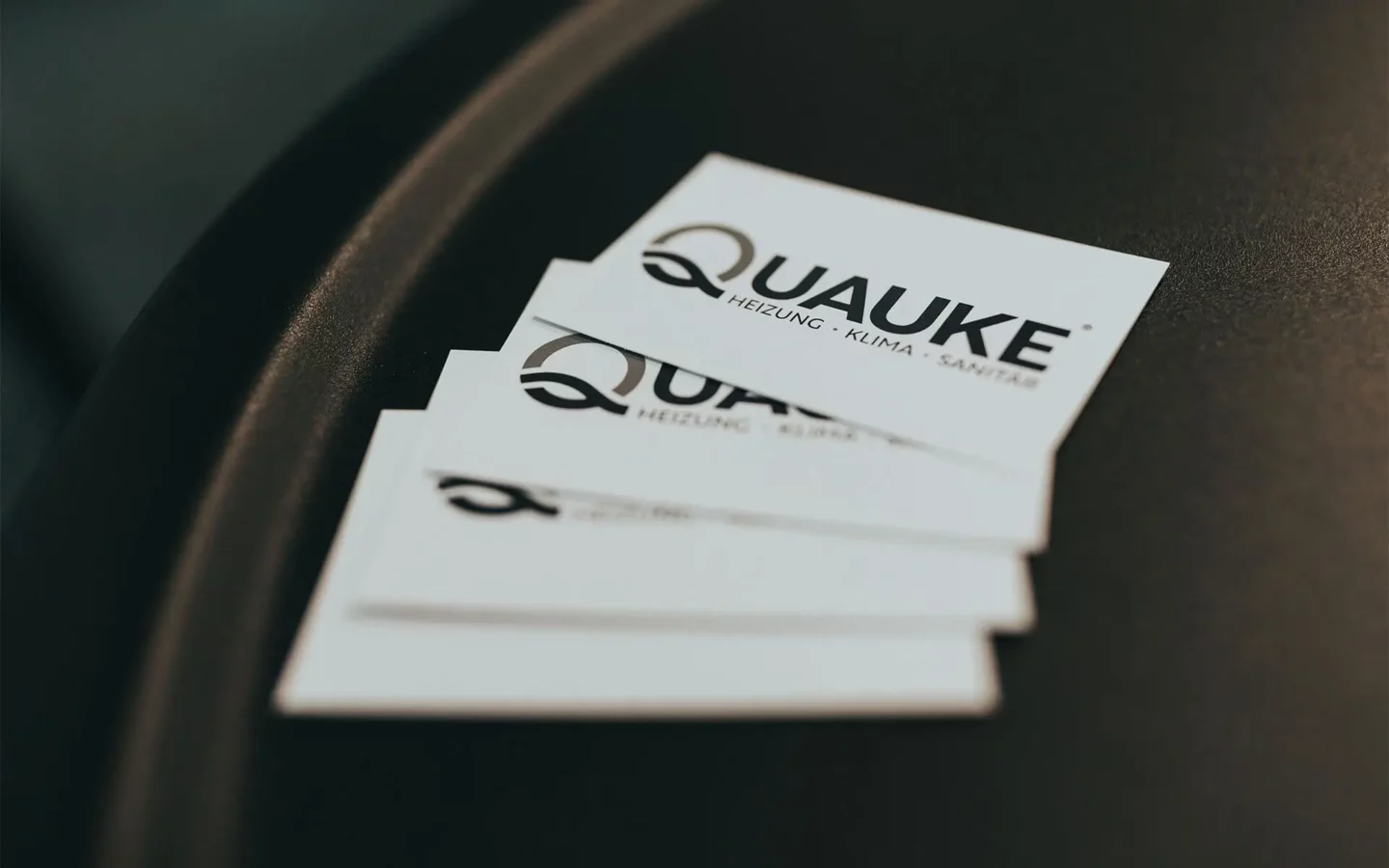 Visitenkarten der Quauke GmbH auf Tisch